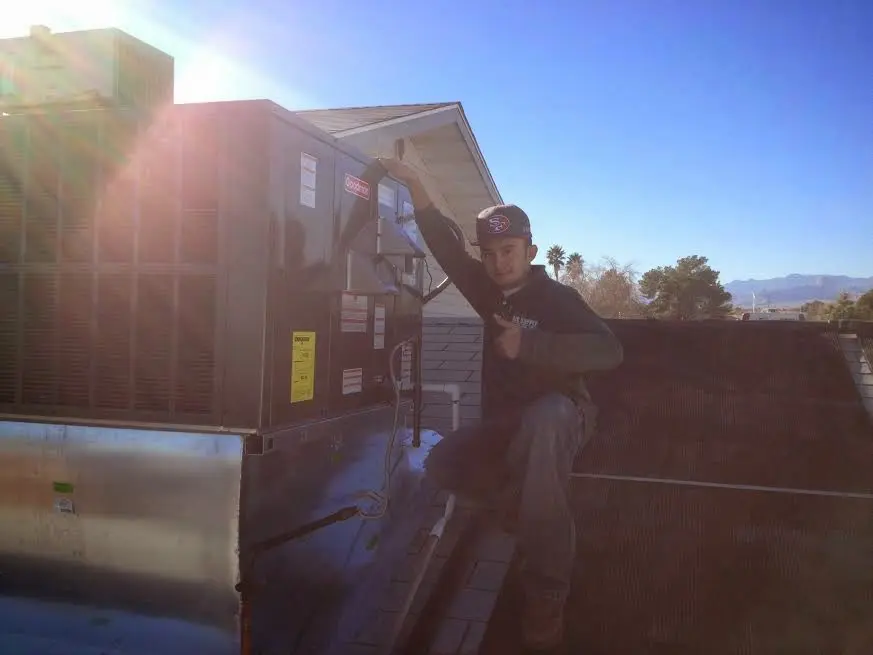 HVAC technician performing AC Tune-Up on a rooftop unit in Tillmans Corner
